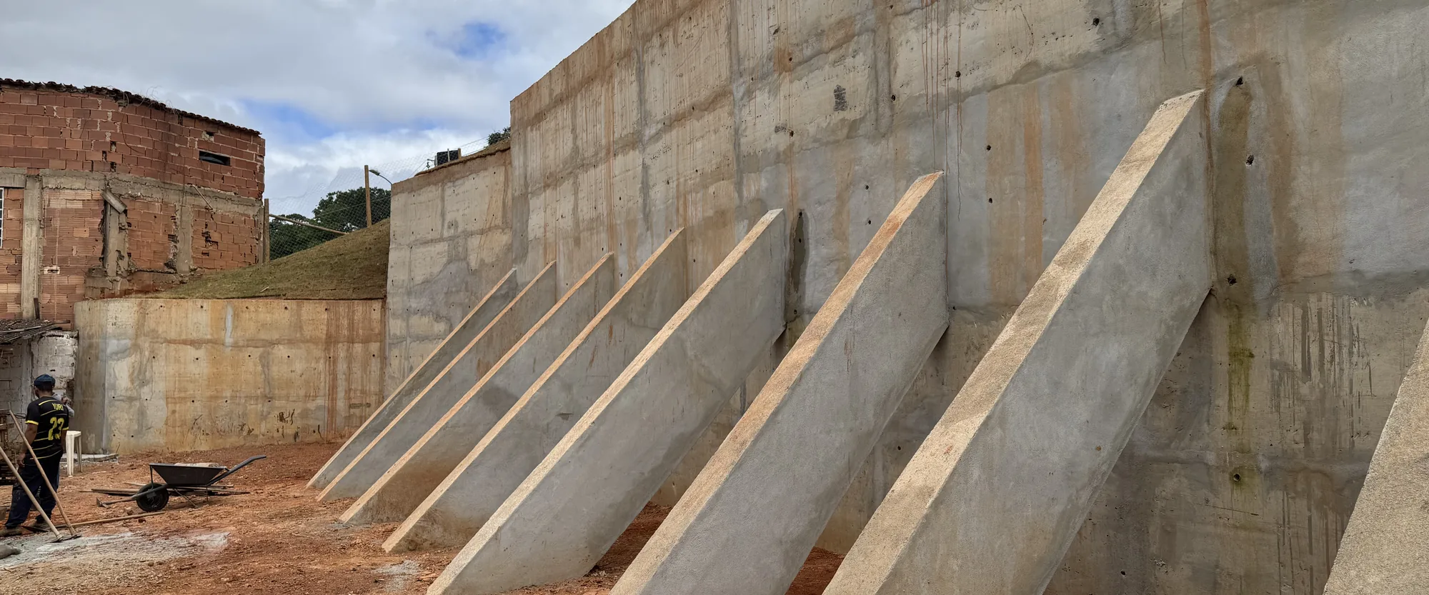 Muro de arrimo em concreto armado com contrafortes, executado em terreno com desnível acentuado